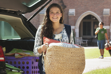 A girl holding a basket outside of a car.