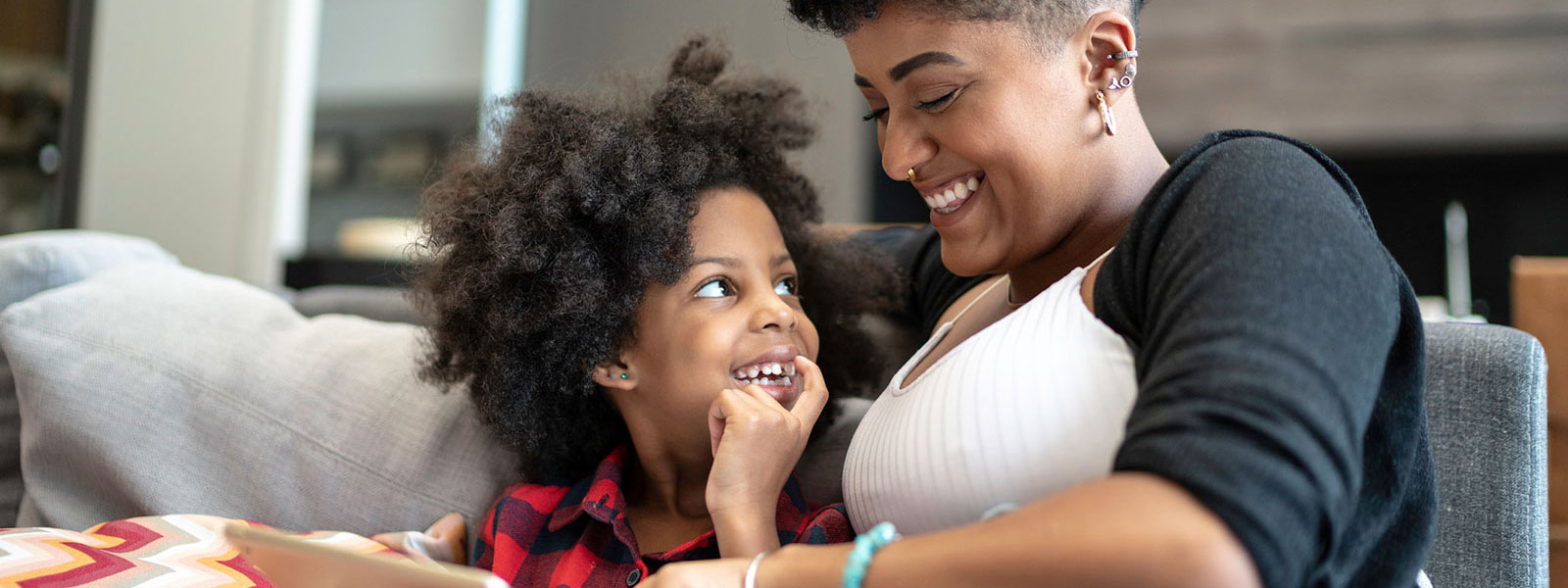 Mother and daughter using tablet in living room