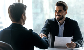 Two business men shaking hands in office