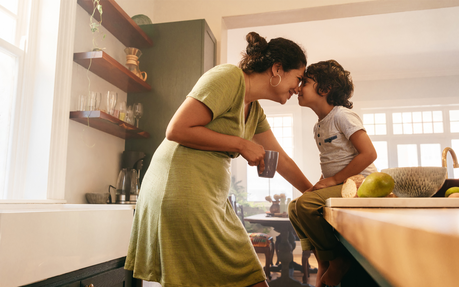 A mom nose to nose with her son in the kitchen.