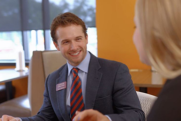 A man smiling at a woman at a table.